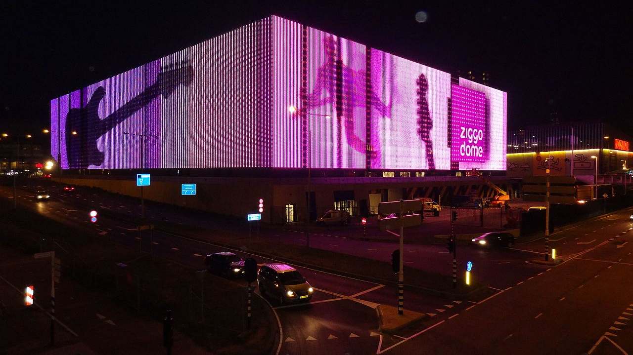 De verlichte gevel van de Ziggo Dome bij avond in Amsterdam-Zuidoost